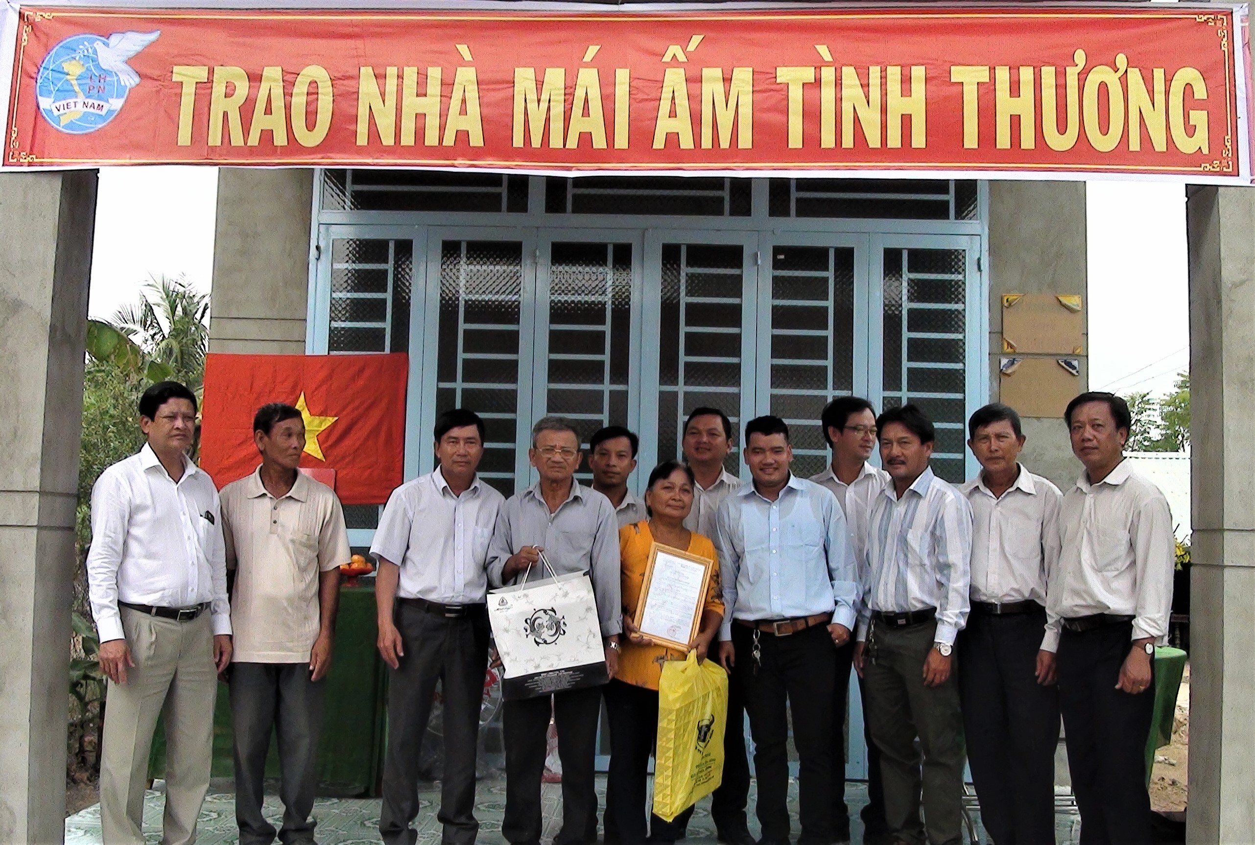Đại biểu huyện, xã và đơn vị tài trợ chụp ảnh lưu niệm cùng gia đình bà Nguyễn Thị Bẻ.jpg