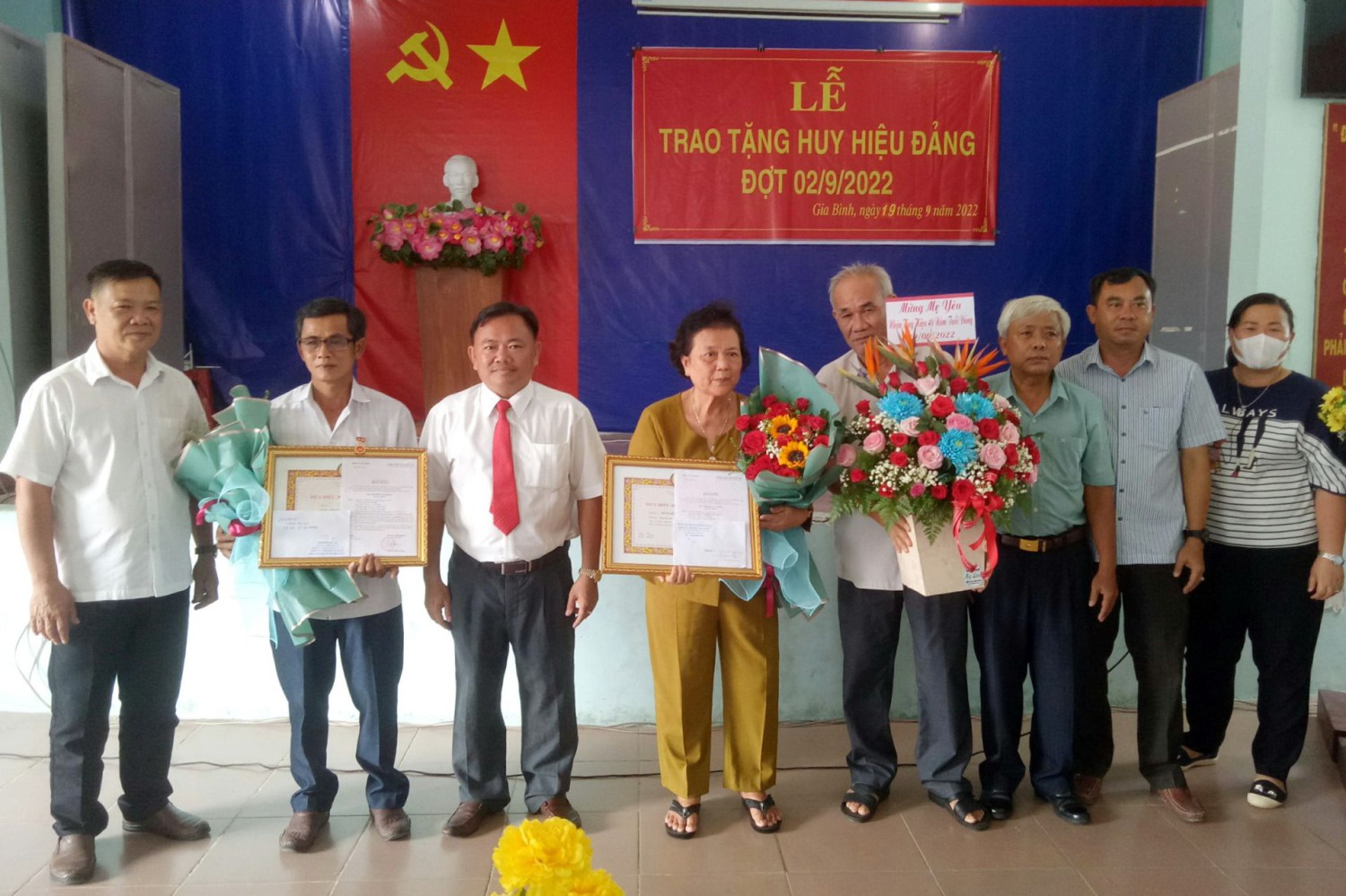 Ông Hà Minh Dảo- Phó Chủ tịch UBND Thị xã (thứ ba từ trái qua) trao Huy hiệu Đảng cho các đảng viên