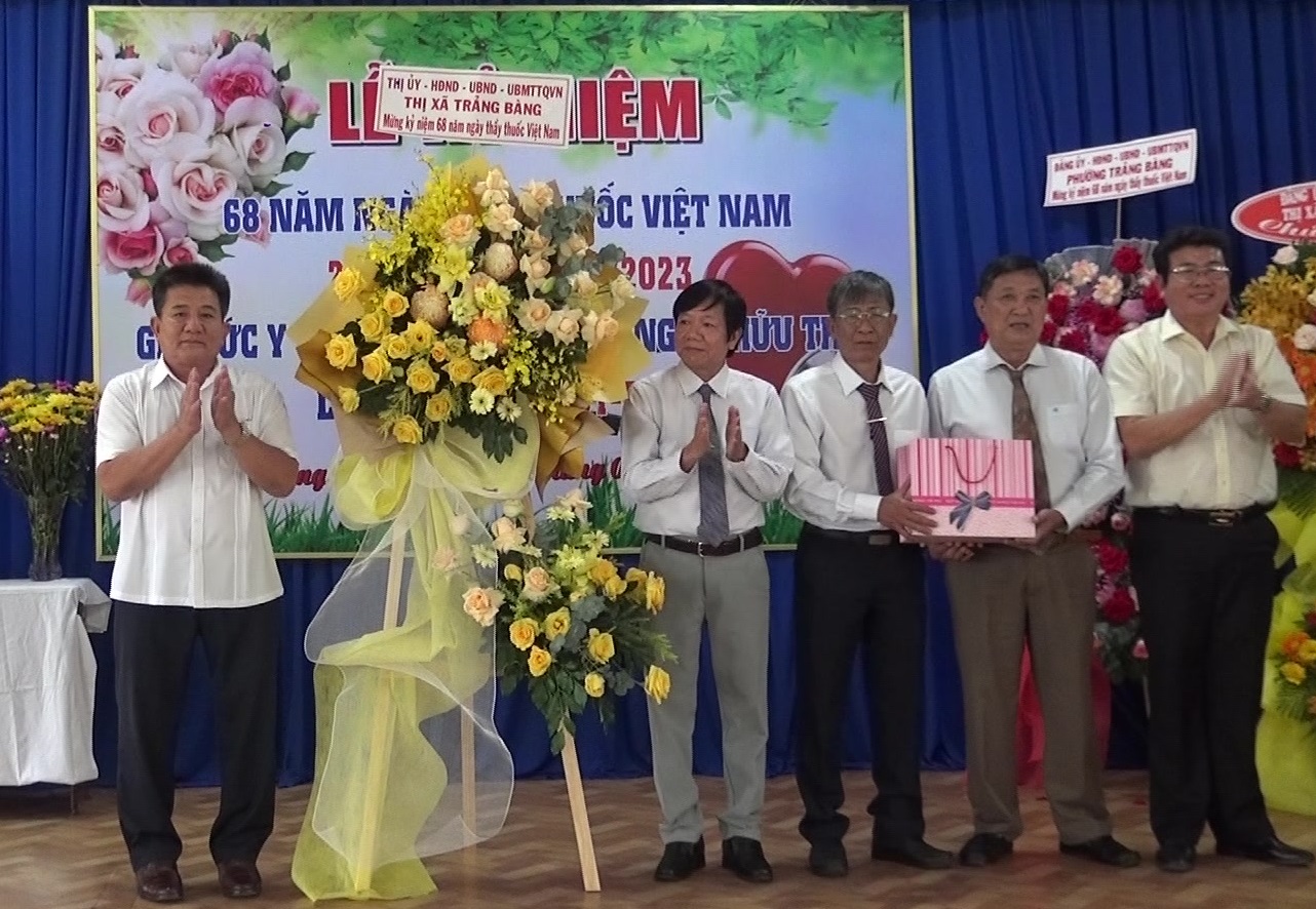 Ông Võ Văn Dũng- Bí thư Thị ủy Trảng Bàng (bên trái) tặng hoa chúc mừng đội ngũ cán bộ y tế thị xã Trảng Bàng.