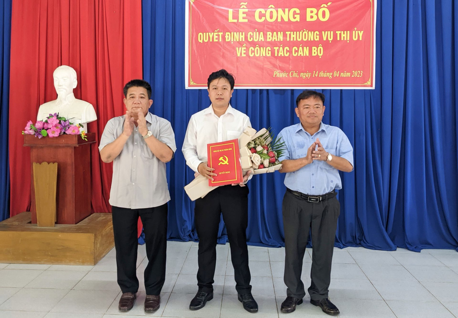 Bí thư Thị uỷ Trảng Bàng Võ Văn Dũng (bìa trái) và ông Hà Minh Dảo- Phó Chủ tịch UBND thị xã trao quyết định và tặng hoa cho ông Trần Minh Tùng.