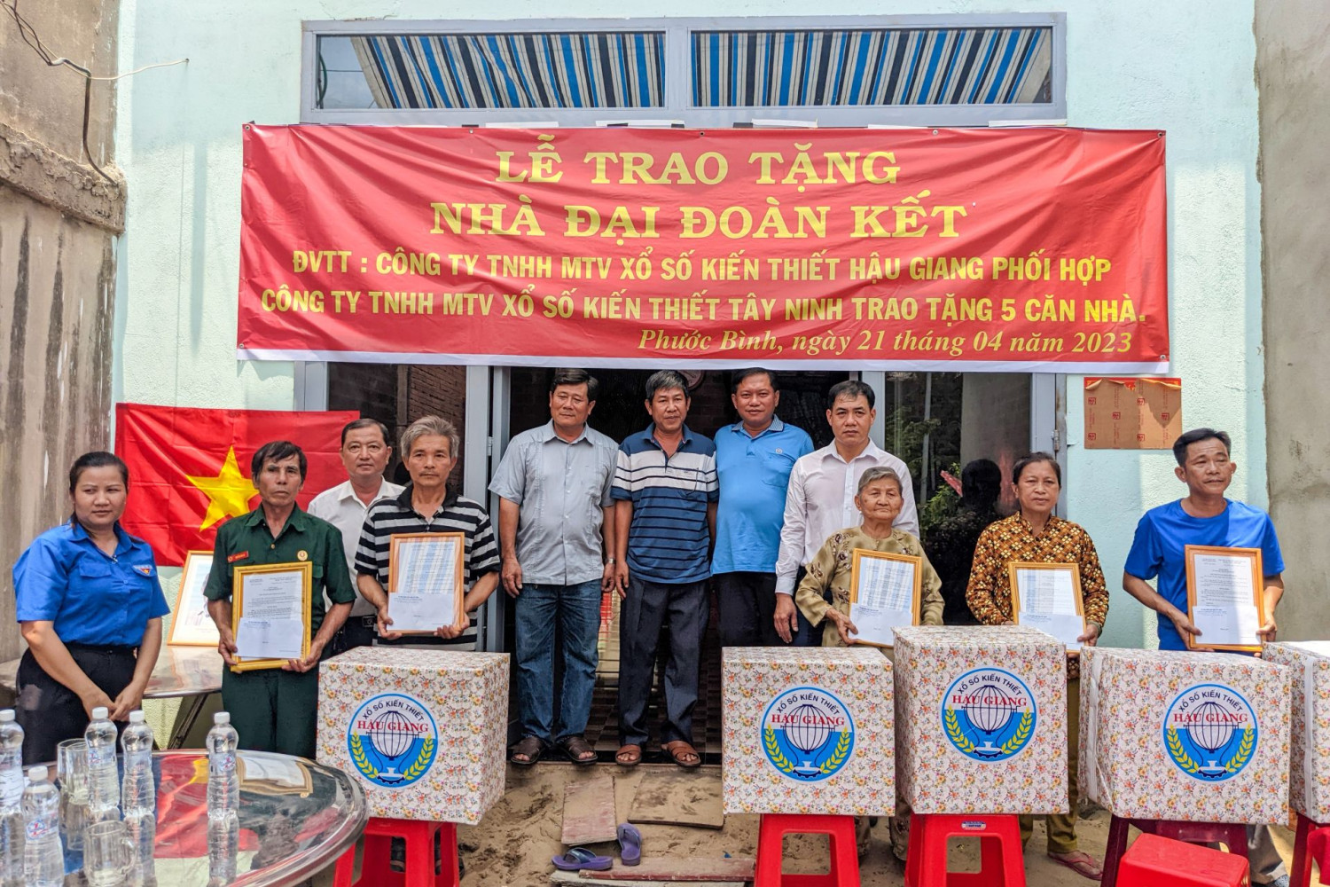 Lãnh đạo xã Phước Bình và đơn vị tài trợ chụp ảnh lưu niệm cùng các gia đình được tặng nhà.