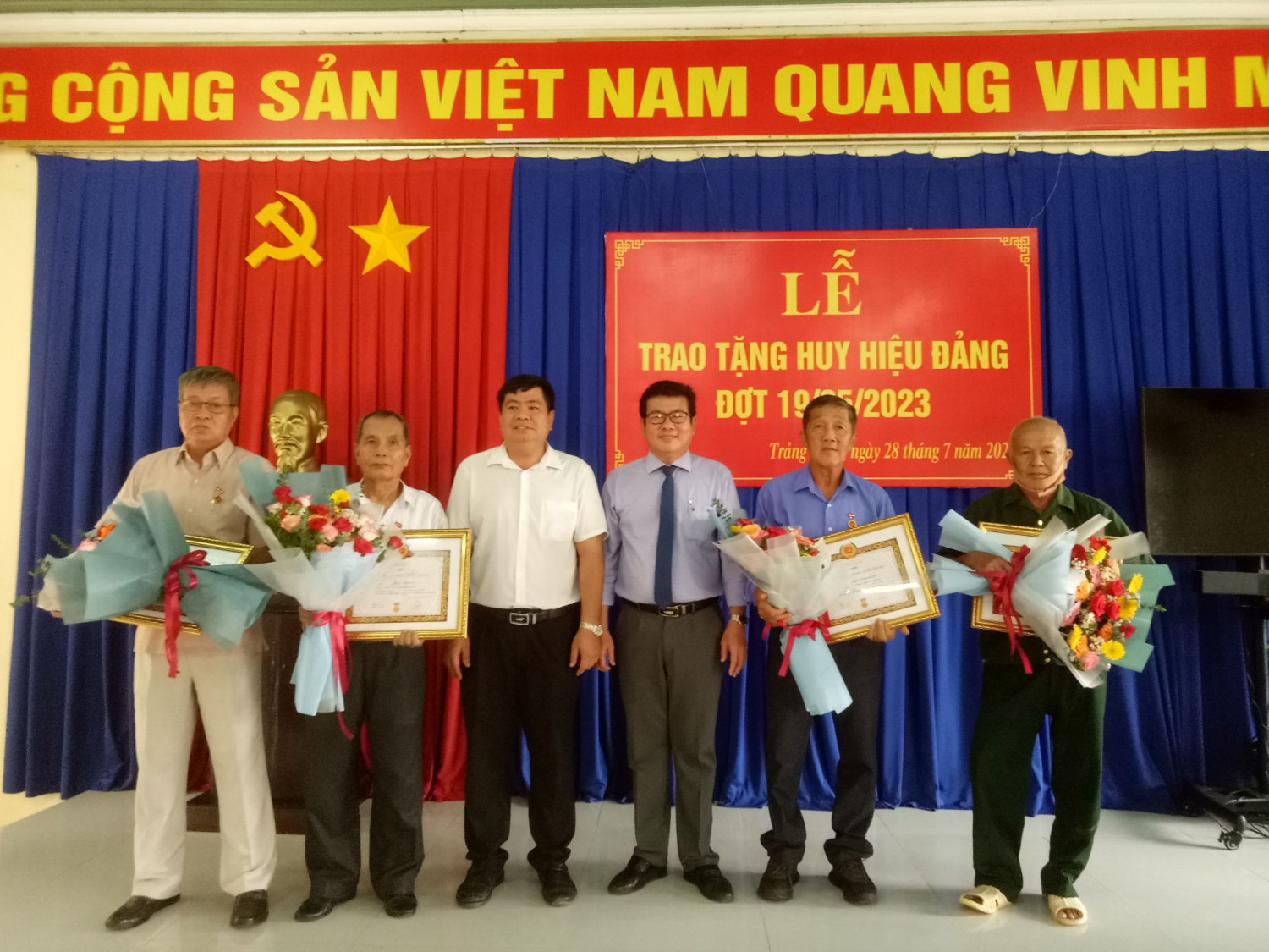 Ông Hồ Văn Hồng- Phó Bí thư Thường trực Thị uỷ, Chủ tịch HĐND Thị xã (thứ ba từ phải qua) tặng hoa, trao tặng Huy hiệu Đảng cho các đảng viên.