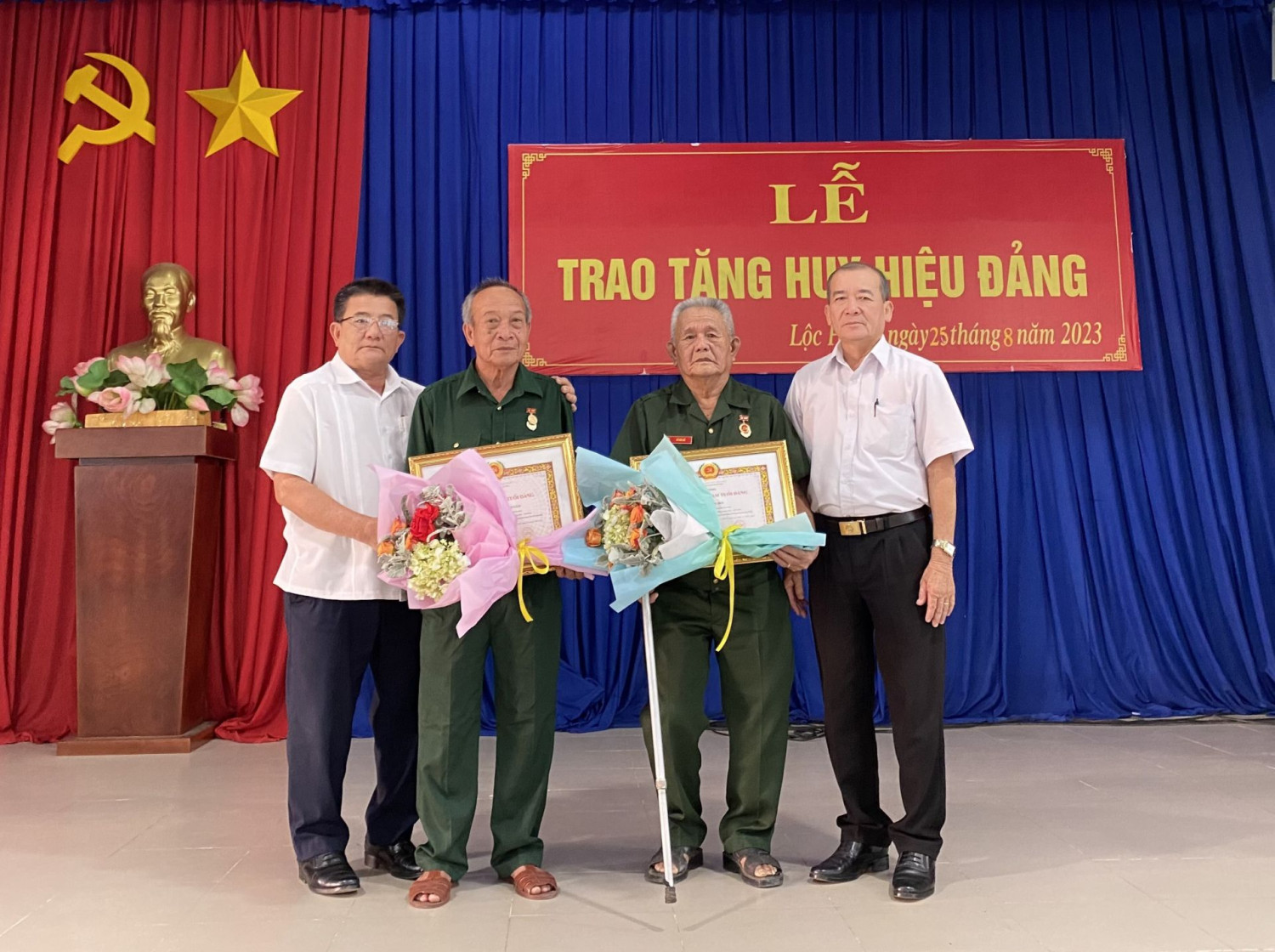 Ông Võ Văn Dũng- Bí thư Thị uỷ Trảng Bàng (bìa trái) trao Huy hiệu cho 2 đảng viên.